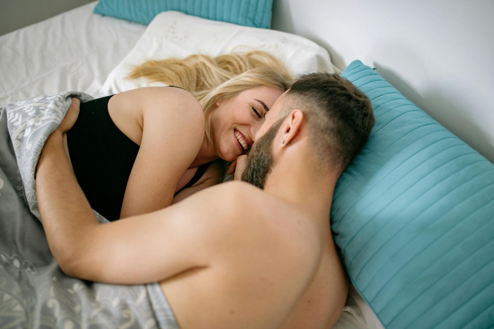 Man and woman cuddling in bed as a wellness program
